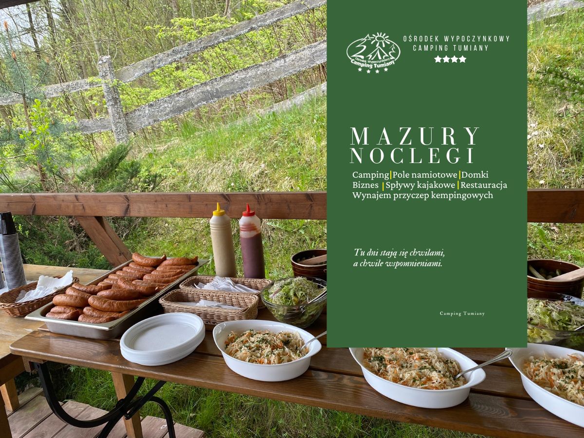 Bufet z grillowanymi potrawami przy drewnianej wiacie oraz zielona plansza Campingu Tumiany